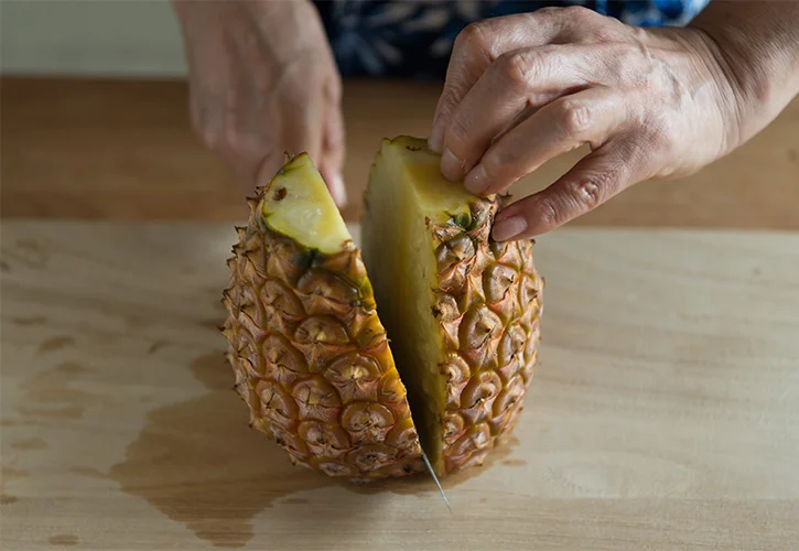 パイナップルの上から包丁を入れる