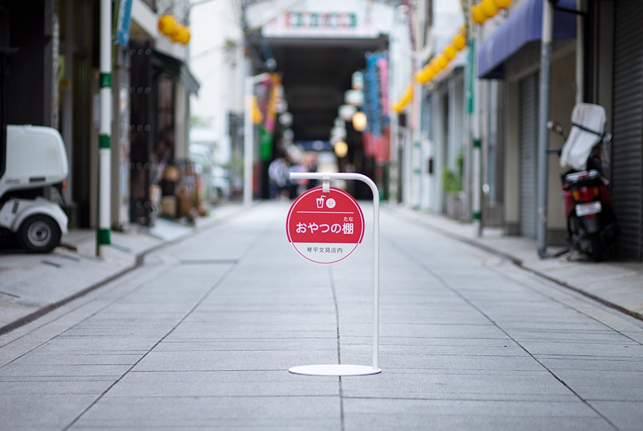 琴平の商店街に立つ「おやつの棚 琴平文具店内」の看板